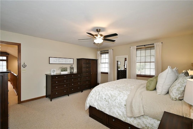 bedroom featuring multiple windows, light carpet, and ceiling fan