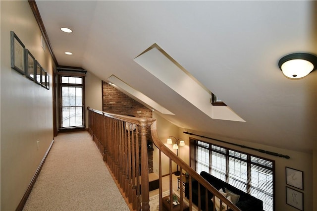 corridor with vaulted ceiling and light colored carpet