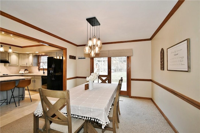 carpeted dining room featuring crown molding, sink, and a notable chandelier