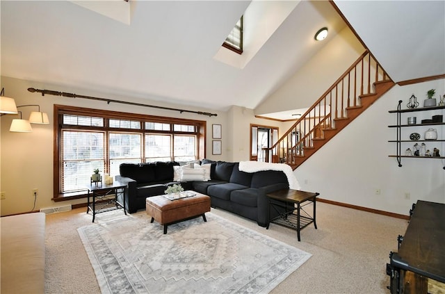 living room with carpet flooring and vaulted ceiling with skylight