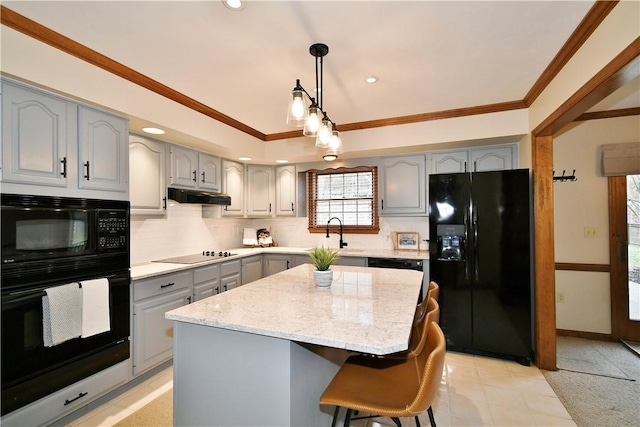 kitchen with crown molding, gray cabinets, a kitchen island, pendant lighting, and black appliances