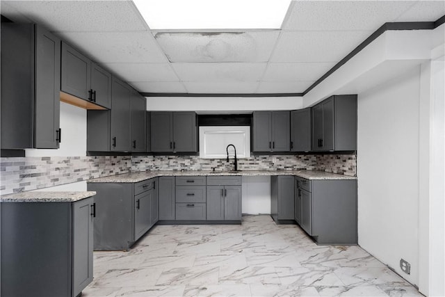 kitchen with a paneled ceiling, sink, decorative backsplash, and gray cabinetry