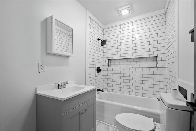 full bathroom featuring vanity, toilet, and tiled shower / bath