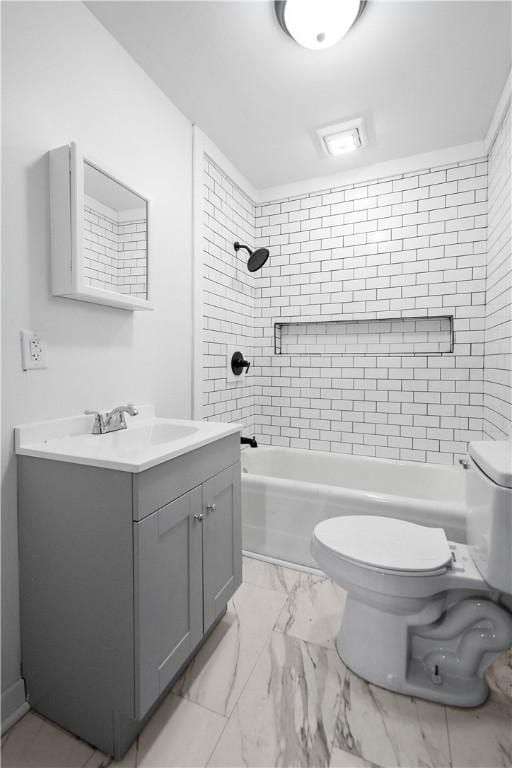 full bathroom with tiled shower / bath, vanity, and toilet