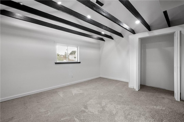 unfurnished bedroom with light carpet and lofted ceiling with beams