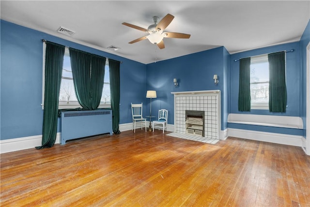 2515 Middle Rd, Hampton, PA 15116 - living room featuring radiator heating unit, ceiling fan, a tiled fireplace, and hardwood / wood-style floors