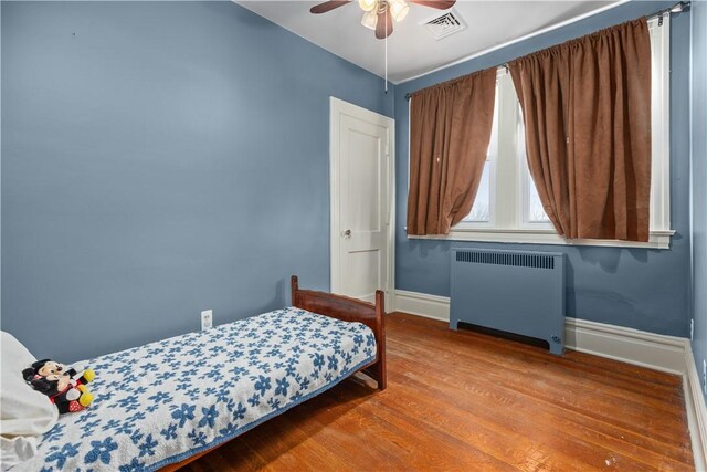 2515 Middle Rd, Hampton, PA 15116 - bedroom with radiator heating unit, baseboards, wood finished floors, and a ceiling fan
