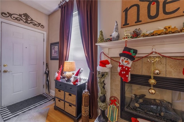 entrance foyer featuring a tiled fireplace, plenty of natural light, and hardwood / wood-style floors