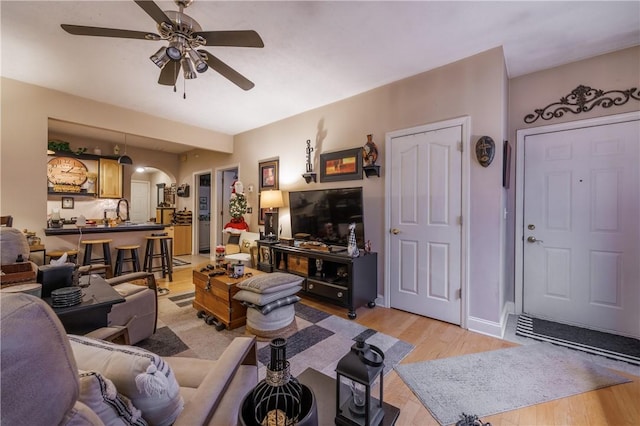 living room featuring ceiling fan and light hardwood / wood-style flooring