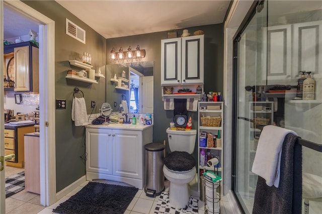 bathroom featuring tile patterned floors, vanity, toilet, and an enclosed shower