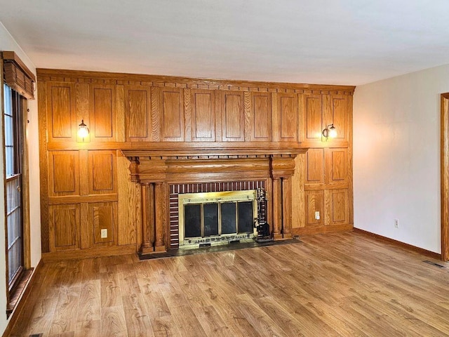 unfurnished living room featuring a brick fireplace and light wood-type flooring