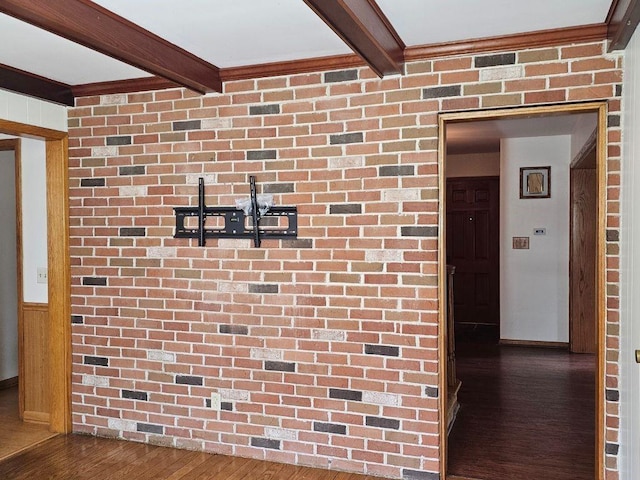 hall with dark hardwood / wood-style flooring, brick wall, and beam ceiling