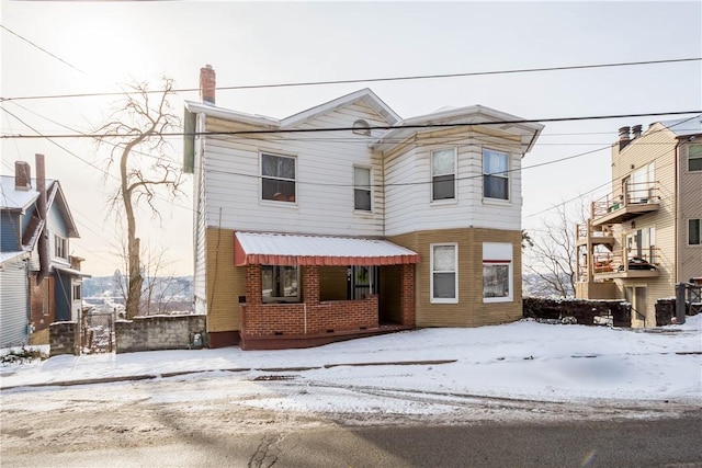 view of front of house featuring a chimney and brick siding