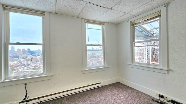 spare room with carpet flooring, a paneled ceiling, and baseboard heating