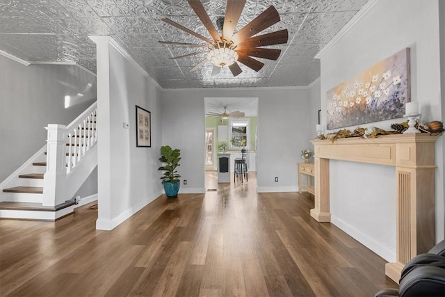 entryway featuring dark wood-type flooring, ceiling fan, and ornamental molding