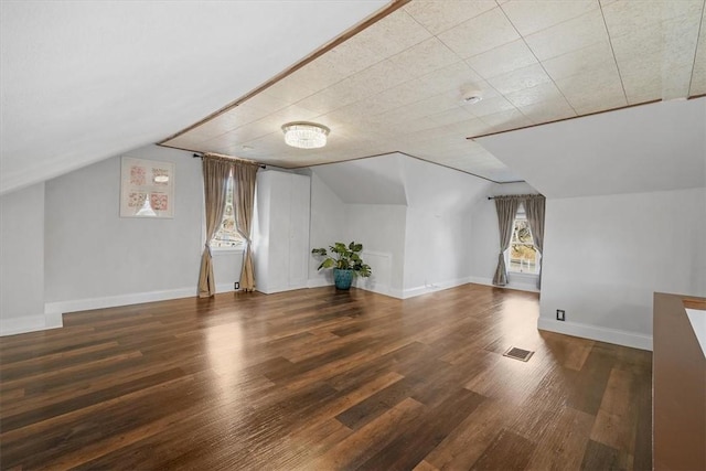 bonus room featuring dark wood-type flooring and vaulted ceiling