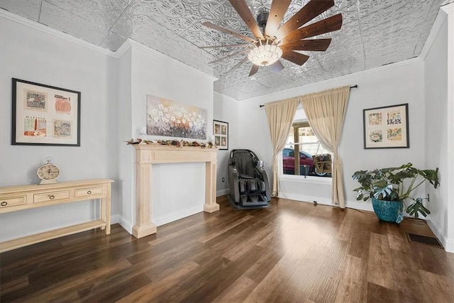 sitting room with ornamental molding and dark hardwood / wood-style floors