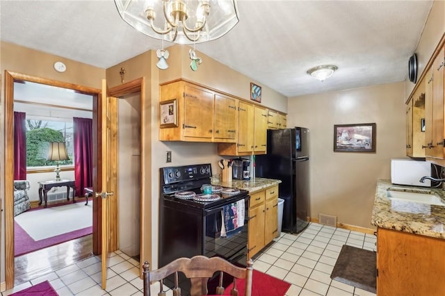 kitchen with light tile patterned floors, decorative light fixtures, sink, and black appliances