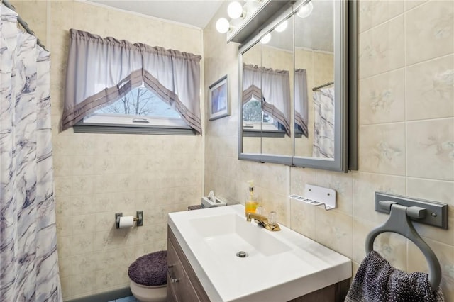 bathroom featuring walk in shower, vanity, toilet, and tile walls