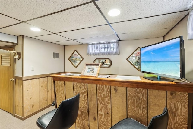 bar featuring a drop ceiling, wooden walls, and carpet flooring