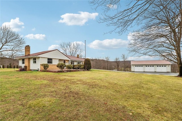 view of yard with a garage and an outbuilding