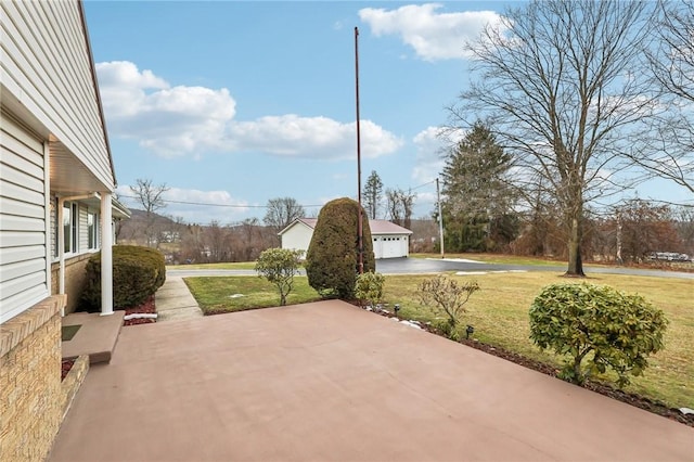 view of patio featuring an outbuilding and a garage