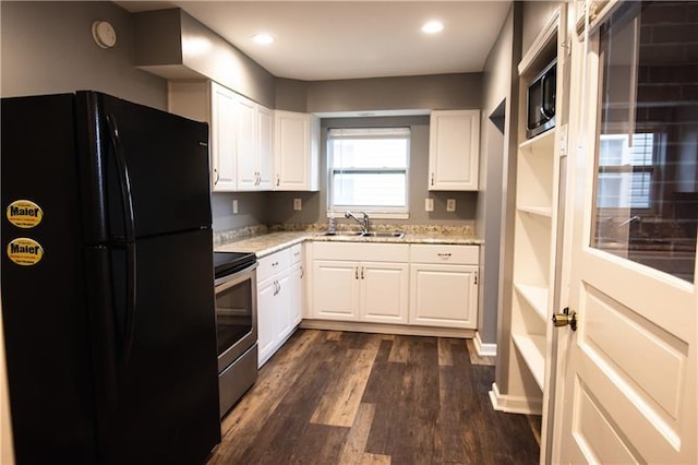 kitchen with black fridge, electric stove, sink, and white cabinets