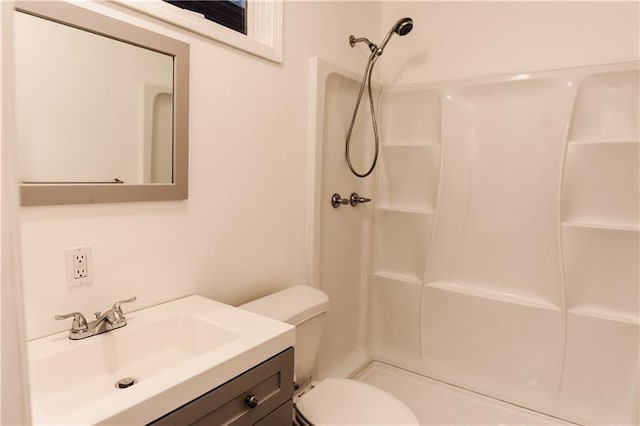 bathroom featuring vanity, toilet, and a shower