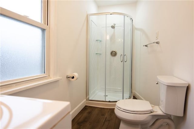 bathroom featuring toilet, an enclosed shower, and hardwood / wood-style floors