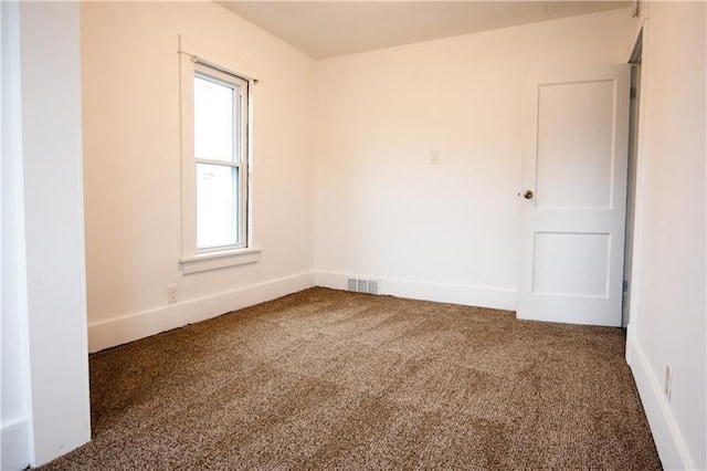 spare room with dark carpet