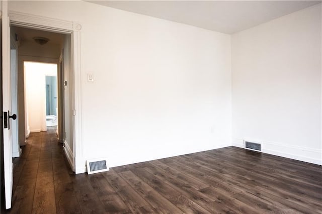 spare room featuring dark wood-type flooring