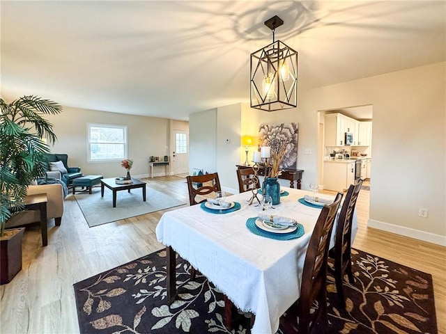 dining area featuring a notable chandelier and light hardwood / wood-style flooring