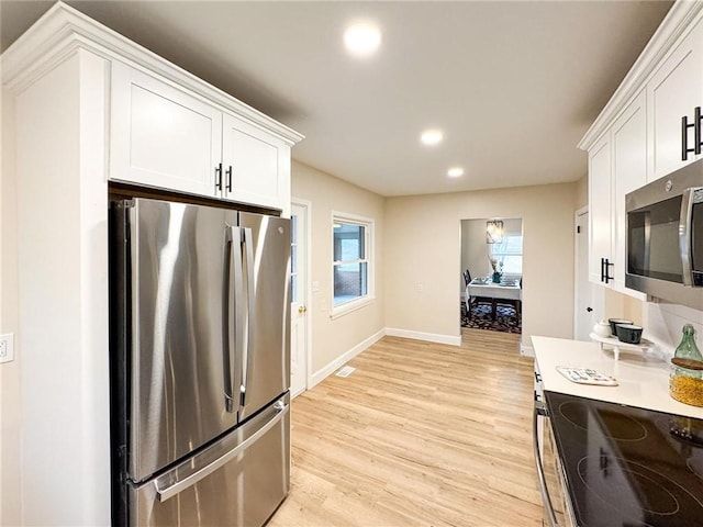 kitchen with white cabinetry, appliances with stainless steel finishes, and light wood-type flooring