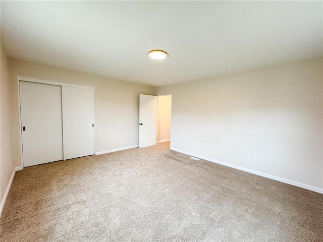 unfurnished bedroom with carpet flooring and a closet