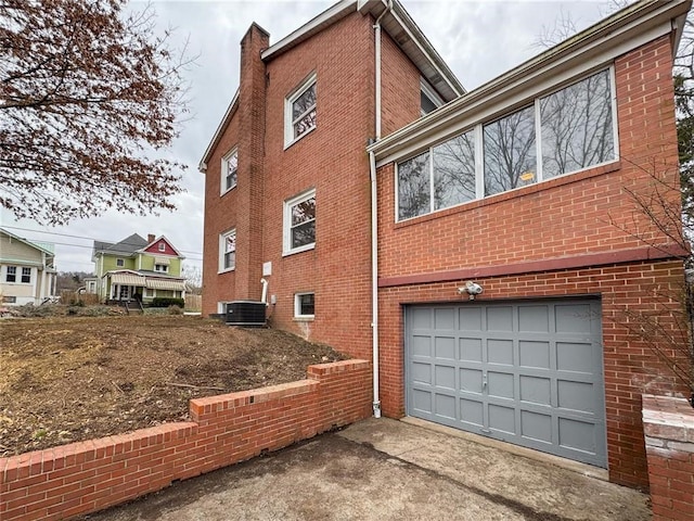 view of side of property featuring a garage and central air condition unit