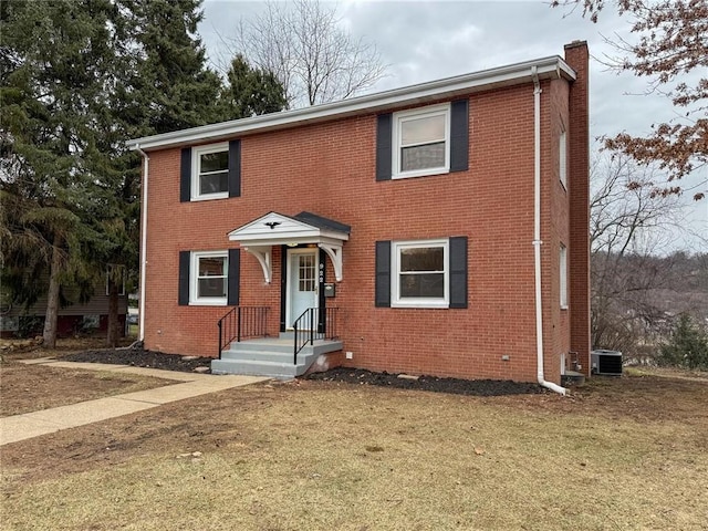 view of front of home featuring central AC unit and a front yard