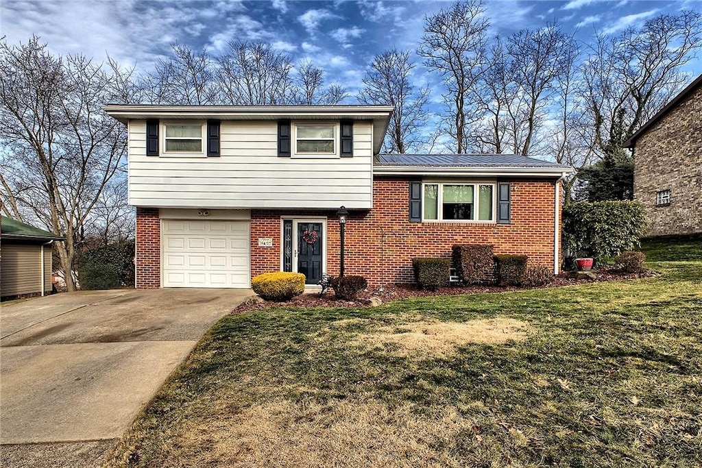 tri-level home with a garage and a front lawn