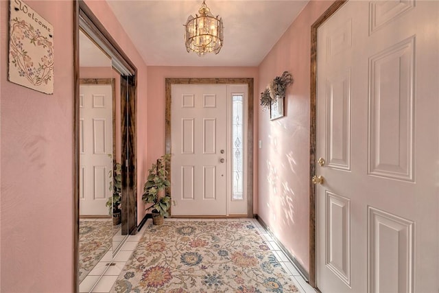 entryway with light tile patterned floors and a chandelier