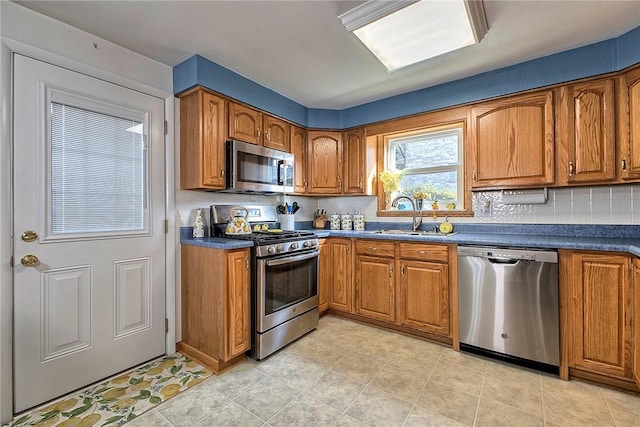 kitchen with tasteful backsplash, appliances with stainless steel finishes, and sink