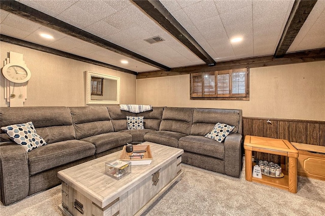 living room with beamed ceiling and light colored carpet