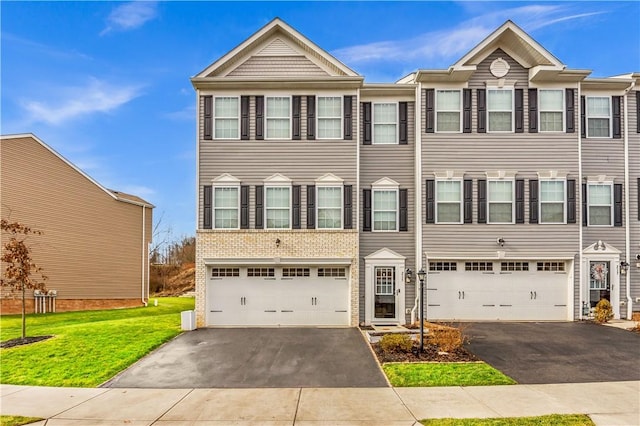 multi unit property featuring a garage and a front lawn