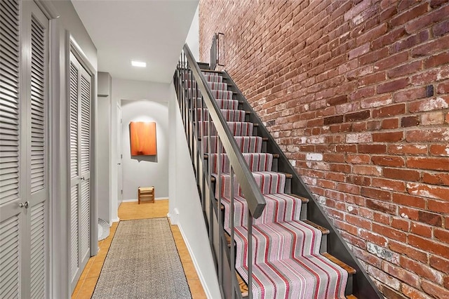 stairs featuring brick wall