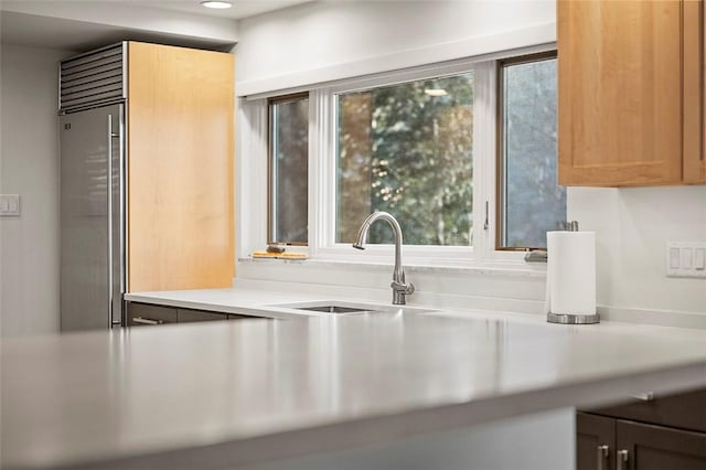 kitchen featuring a healthy amount of sunlight, sink, and stainless steel built in fridge