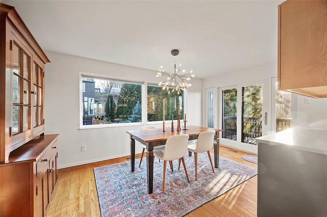 dining space featuring a notable chandelier and light wood-type flooring