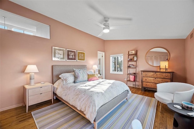 bedroom featuring lofted ceiling, multiple windows, wood-type flooring, and ceiling fan