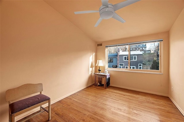 interior space with ceiling fan, vaulted ceiling, and light wood-type flooring