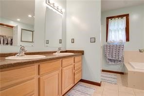 bathroom featuring tile patterned flooring, vanity, and a tub to relax in