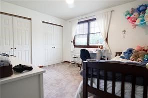 bedroom with multiple closets and carpet