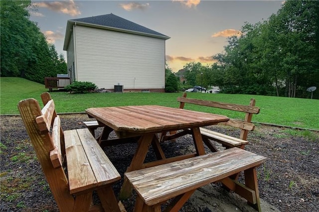 patio terrace at dusk featuring a yard