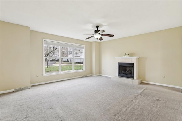 unfurnished living room with ceiling fan, a fireplace, and carpet floors